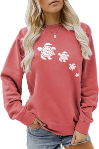Detail of coral red crewneck sweatshirt with white sea turtle print on soft fabric