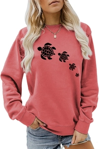 Detail of coral red crewneck sweatshirt featuring a family of black turtle prints on fabric