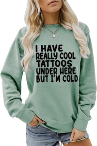 Close-up of green long sleeve sweatshirt featuring ribbed cuffs and graphic text print