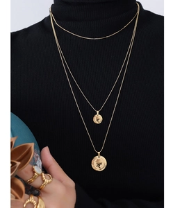 Detailopname van de drielaagse goudkleurige titaniumstalen muntketting met kralenketting