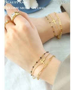 Detailed view of 5-piece gold jewelry set with layered bracelets and zircon rings