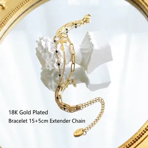 Three-layer 18k gold plated stackable cross bracelet with black beads on a white bust