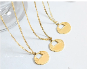 Détail de trois colliers à pendentif serrure Ruyi dorée avec une élégante chaîne martelée