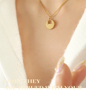 Vue détaillée du collier avec pendentif serrure dorée mate sur chaîne en acier titane