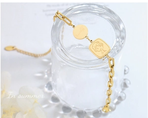 Détail du bracelet chaîne plaqué or 18 carats avec breloque Lucky et pendentif garçon
