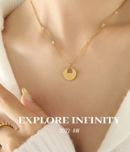 Détail macro du pendentif serrure dorée sur une chaîne fine en acier titane