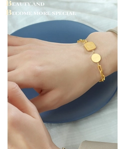 Détail du bracelet doré avec pendentif rond Lucky et breloque carrée de lapin