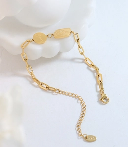 Détail du bracelet doré en titane avec pendentif Lucky et poinçon gravé K18