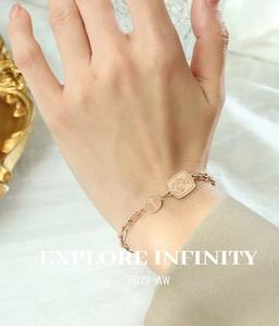Détail du bracelet chaîne trombone rose doré avec breloque Lucky et motif floral