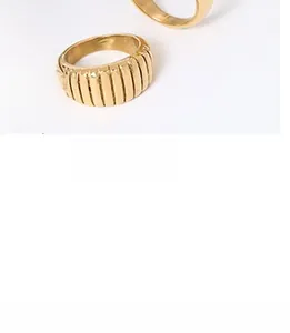 Macro shot of minimalist gold vertical striped ring with polished textured metal surface