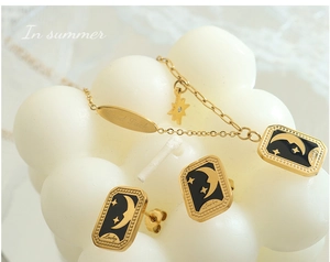 Détail du collier pendentif lune étoile plaqué or 18K et boucles d'oreilles sur dentelle