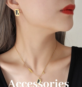 Détail du collier doré avec pendentif lune et étoiles et gravure Lucky sur fond noir
