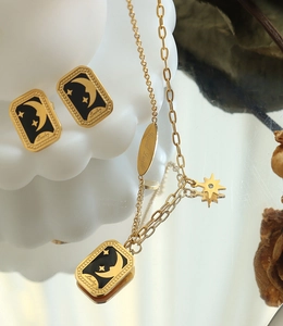 Détails d'un ensemble de bijoux célestes dorés avec pendentif étoile, lune et gravure Lucky