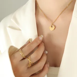 Parure collier serrure dorée et bagues en zircon sur mannequin en costume blanc