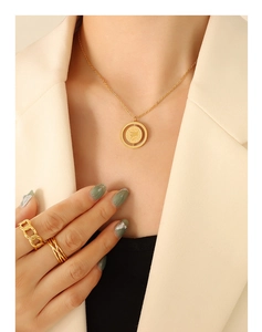 Detail of gold-plated necklace with Nothing is impossible pendant and layered rings