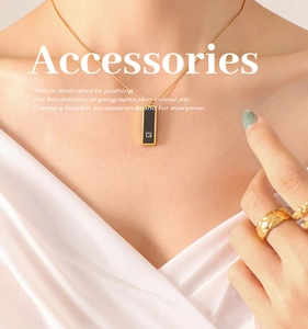 Macro detail of gold plated necklace with black acrylic pendant and quilted pattern ring