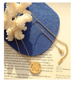 Detail of gold titanium steel necklace with bee pendant and K18 engraving tag