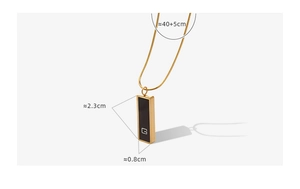 Detailed view of gold snake chain with black acrylic pendant and minimalist G letter charm