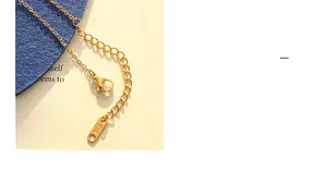 Macro detail of gold lobster clasp and extension chain with K18 engraved tag