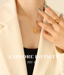 Detail of vintage rotating gold pig pendant necklace and textured rings on model