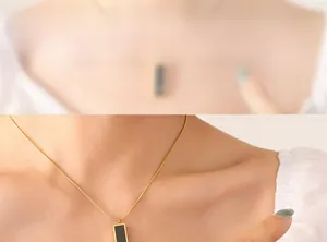 Detailed close-up of a black acrylic pendant necklace with a gold-plated chain