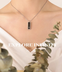Close-up of minimalist black acrylic G-pendant necklace with sleek gold-plated snake chain