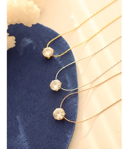 Detailed view of minimalist single stone necklaces in gold, silver, and rose gold finishes
