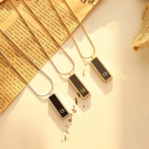 Set of three minimalist black acrylic G-tag necklaces in gold, silver, and rose gold finishes