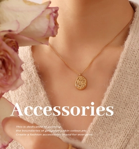 Detailed view of an irregular textured 18K gold-plated necklace on a beige sweater