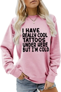 Detail of light pink sweatshirt with 'I HAVE REALLY COOL TATTOOS' slogan text