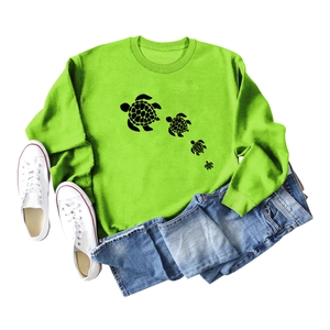Flat lay of bright green sweatshirt with minimalist black sea turtle silhouette prints