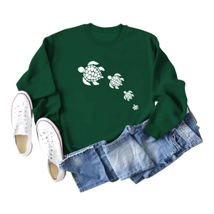 Flat lay of dark green crewneck sweatshirt with white turtle prints and denim jeans