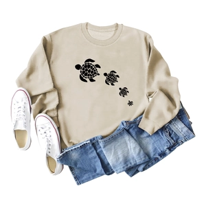 Flat lay of beige turtle print sweatshirt with blue jeans and white sneakers