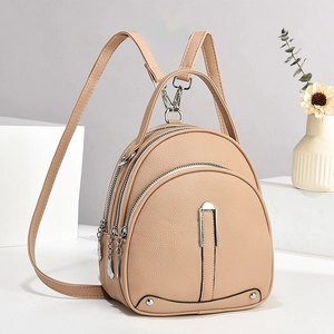Détail d'un sac à dos beige à trois fermetures éclair avec texture grain de cuir