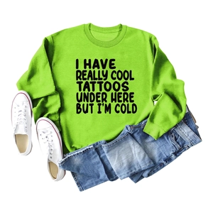 Flat lay of neon green sweatshirt with black text slogan and blue jeans outfit