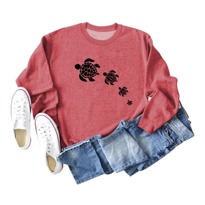 Flat lay of vintage brick red sweatshirt with turtle print, jeans and white sneakers