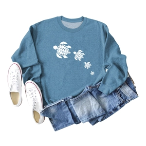 Flat lay of blue crewneck sweatshirt with cute white turtle print and casual denim jeans