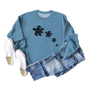 Flat lay of blue crewneck sweatshirt with four turtle silhouettes and casual styling