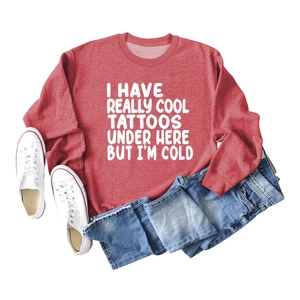 Flat lay of a red long sleeve sweatshirt featuring white I HAVE REALLY COOL TATTOOS text