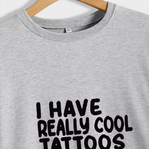 Grey long sleeve crewneck sweatshirt featuring I HAVE REALLY COOL TATTOOS print on a hanger