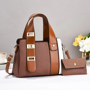 Detailed view of brown textured tote bag set with detachable strap and gold metal hardware