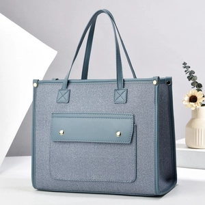 Contrast color canvas tote bag with deep blue fabric and light blue faux leather handles