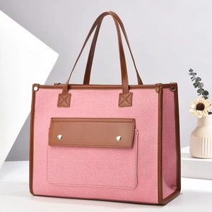 Pink and white canvas tote bag with brown leather trim and front flap pocket detail