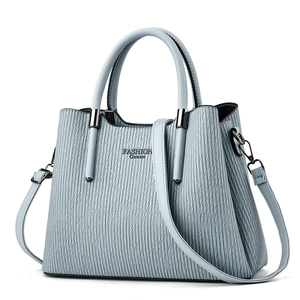Close-up of light blue pleated handbag with dual handles and Fashion Queen lettering