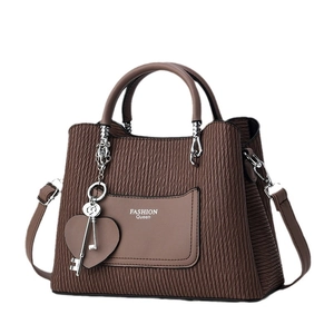 Dark brown pleated tote bag with fashion lettering and heart charm on white background