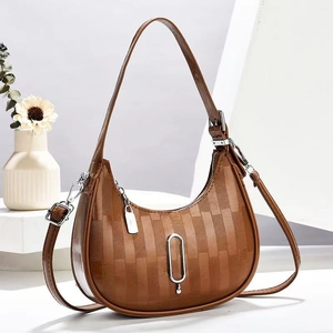 Detailed view of brown moon bag with vertical textures and silver metal buckle