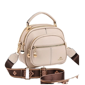 Chic beige crossbody bag with textured leather, dual zippers, and floral wide strap