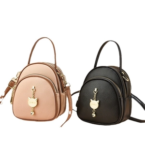 Mini multi-functional pebble leather backpack with decorative cat charm in pink and black