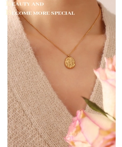 Close-up of irregular textured oval walnut shell pendant necklace in 18K gold plated steel