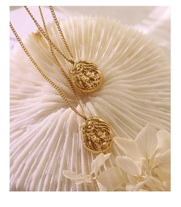 Detail of 18K gold-plated titanium necklace with irregular walnut shell texture pendant